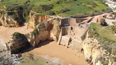 stone staircase in pinhão beach within secluded scenery in lagos, algarve portugal - aerial point of interest panoramic shot