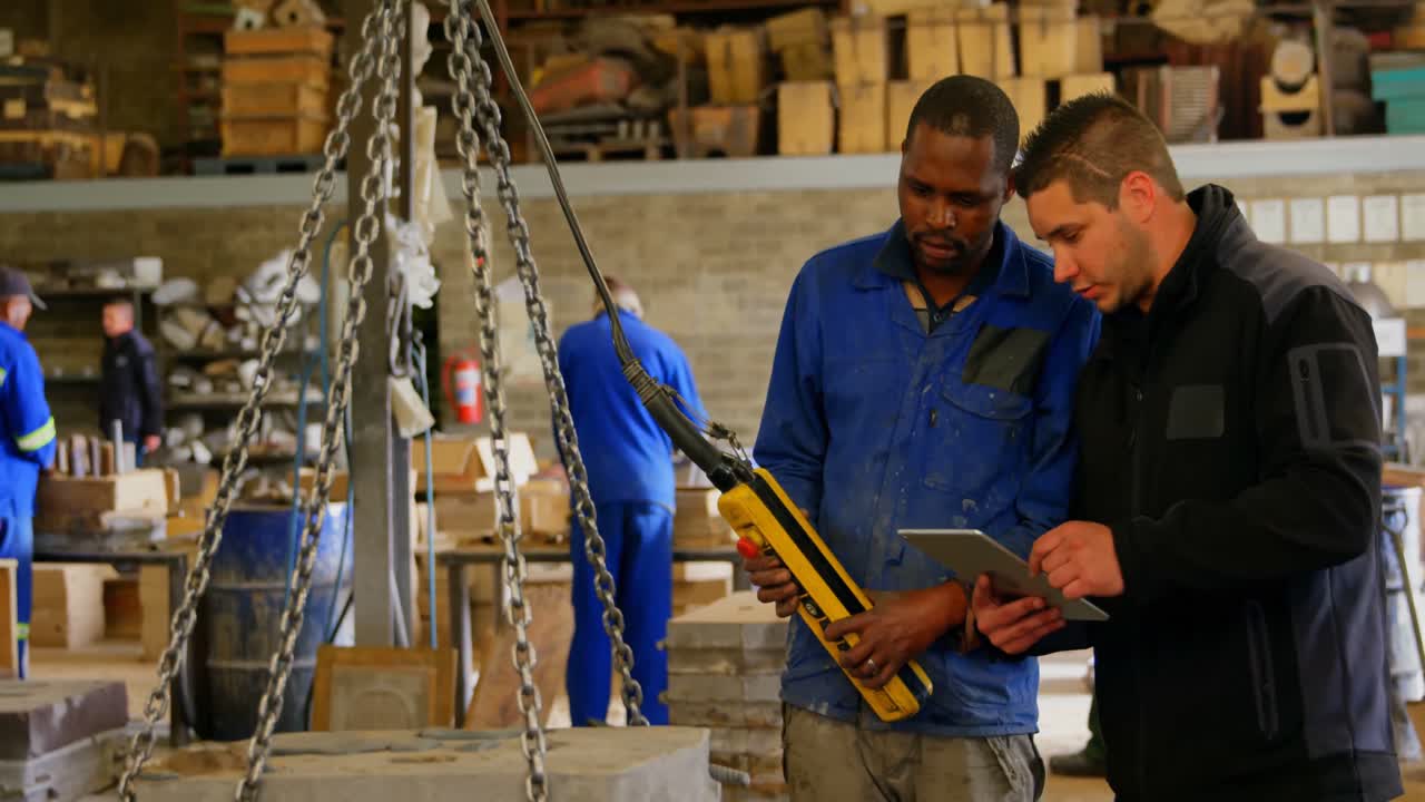 Worker discussing with each other in foundry workshop 4k