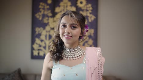 lovely indian bride smiling in front of the camera at mehndi function for her wedding week