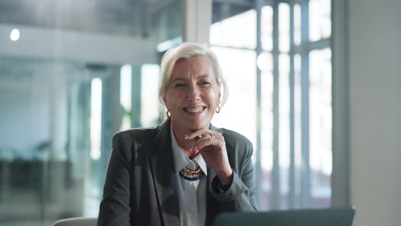 Erfaren forretningskvinde smiler og ser op på moderne kontor