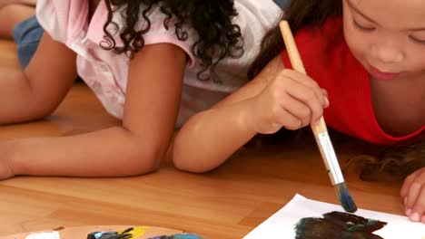chicas tendidas en el suelo y pintando