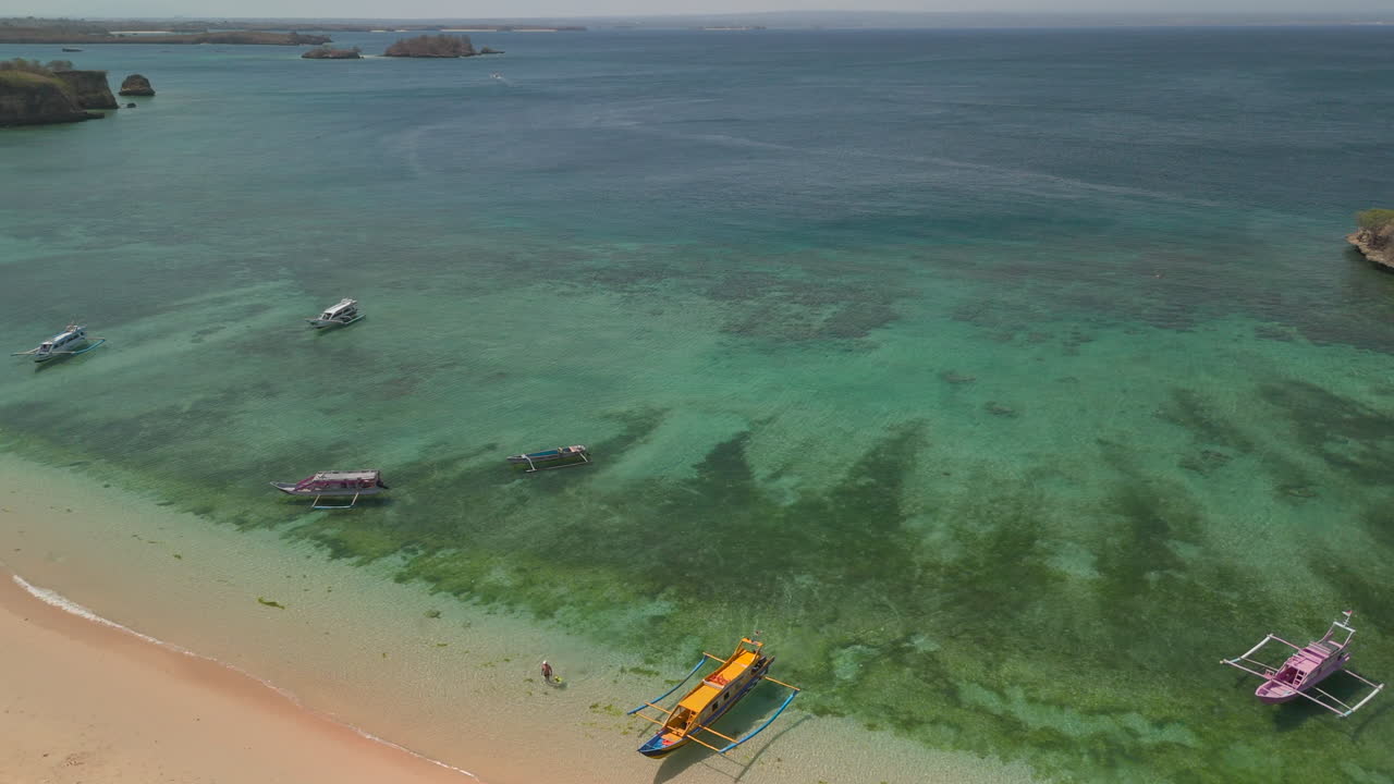 ボートが停泊する熱帯のビーチ、浅く澄んだ海、美しい海岸線、島の景観、旅行先、砂浜、ターコイズブルーのラグーン、夏の自然。ドローンからの眺め。