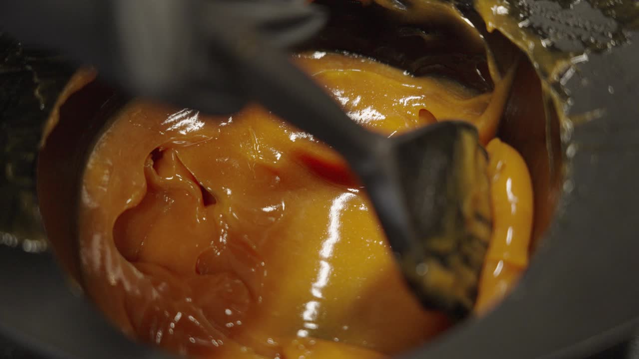 un cepillo se sumerge en pasta de blanqueador para un tratamiento en el salón