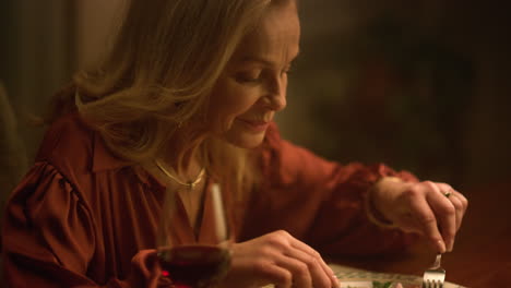 Attractive-senior-woman-eating-salad-in-dusk-luxury-restaurant.-Romantic-dinner