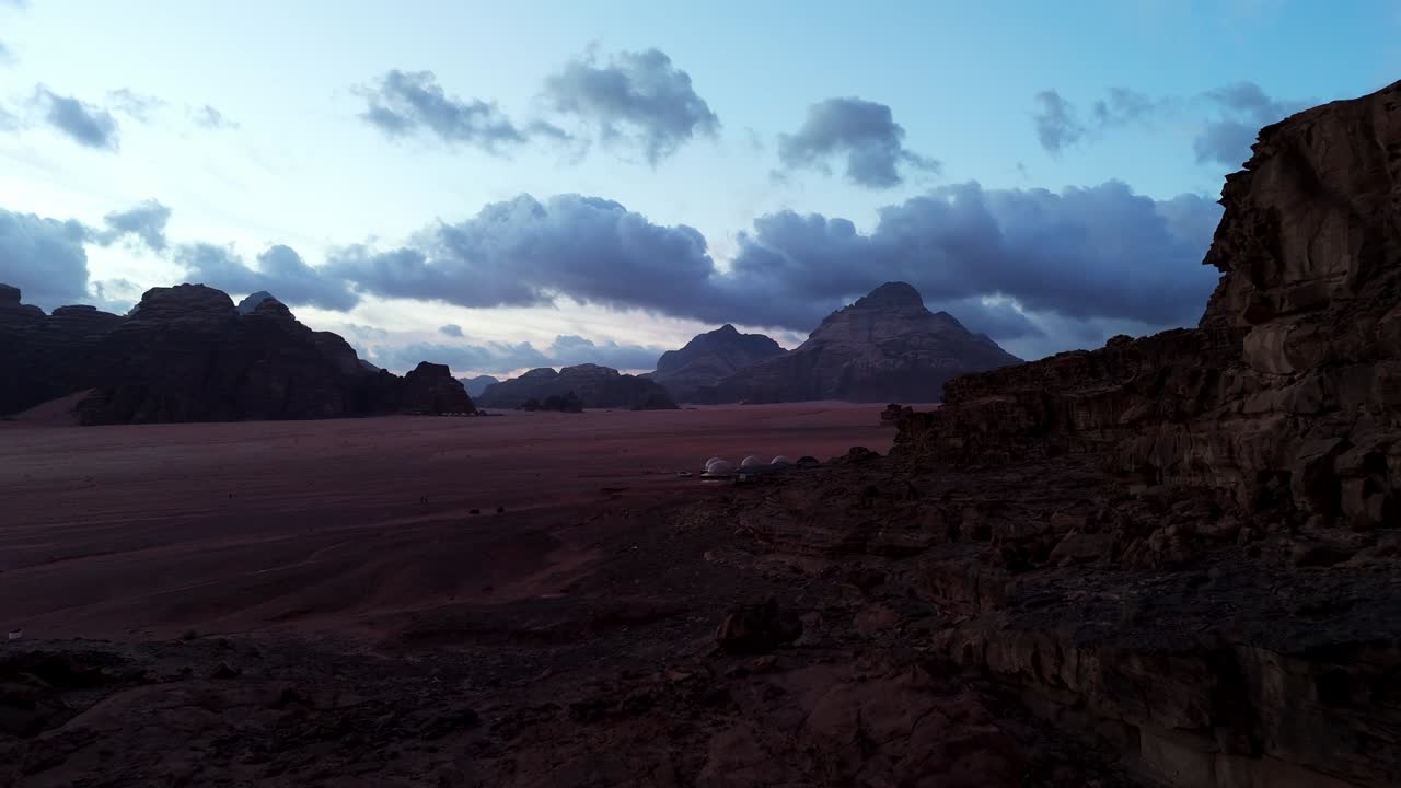 A stunning aerial sequence capturing the soft morning glow over the jagged mountain passes of the Wadi Rum desert Jordanian wilderness