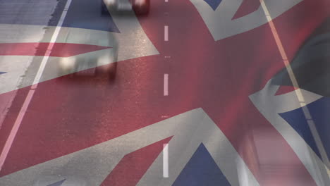 bandera de la unión ondeando sobre el lapso de tiempo de los coches que conducen por la carretera