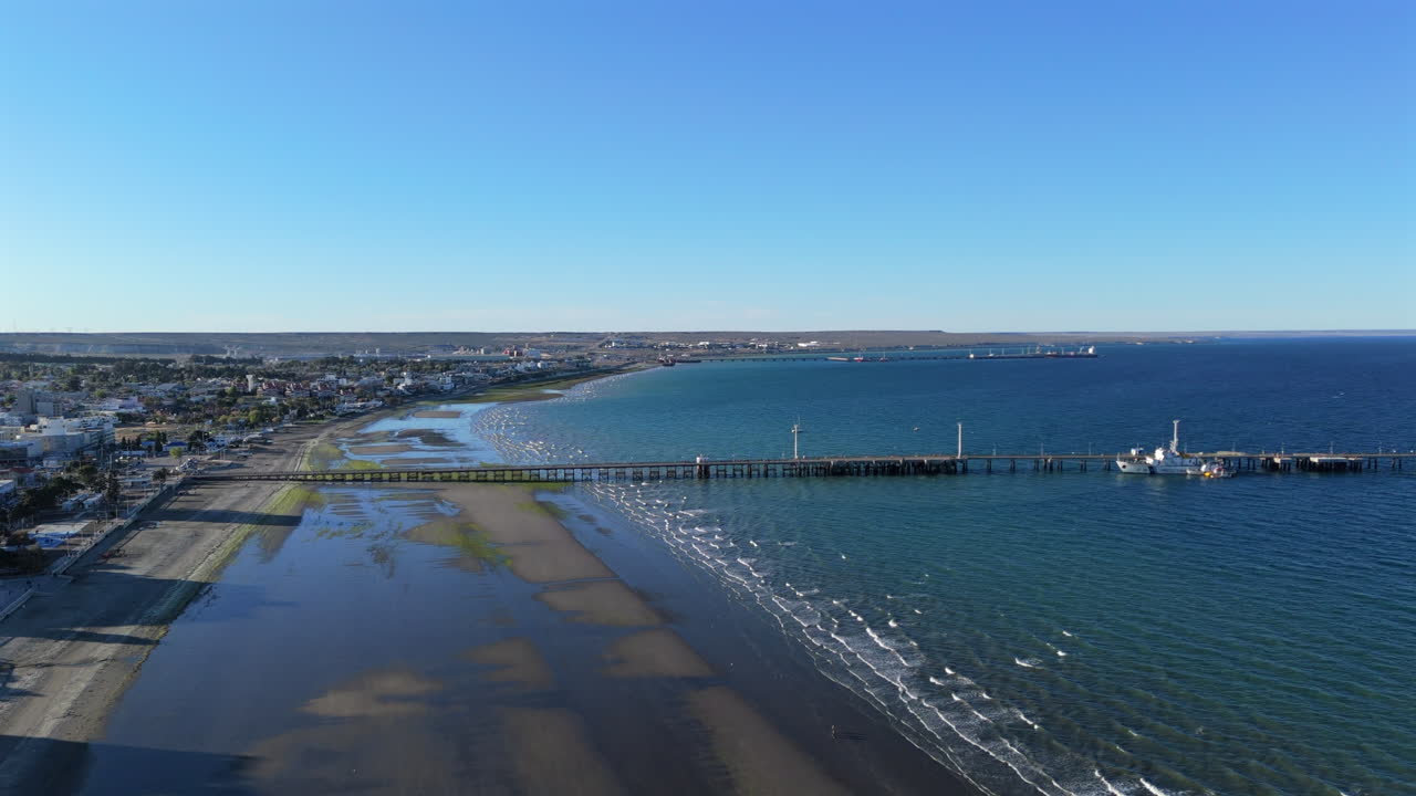 Aerial establishing of coastal landscape, long dock at Puerto Madryn, Patagonian city in Chubut Province Argentina