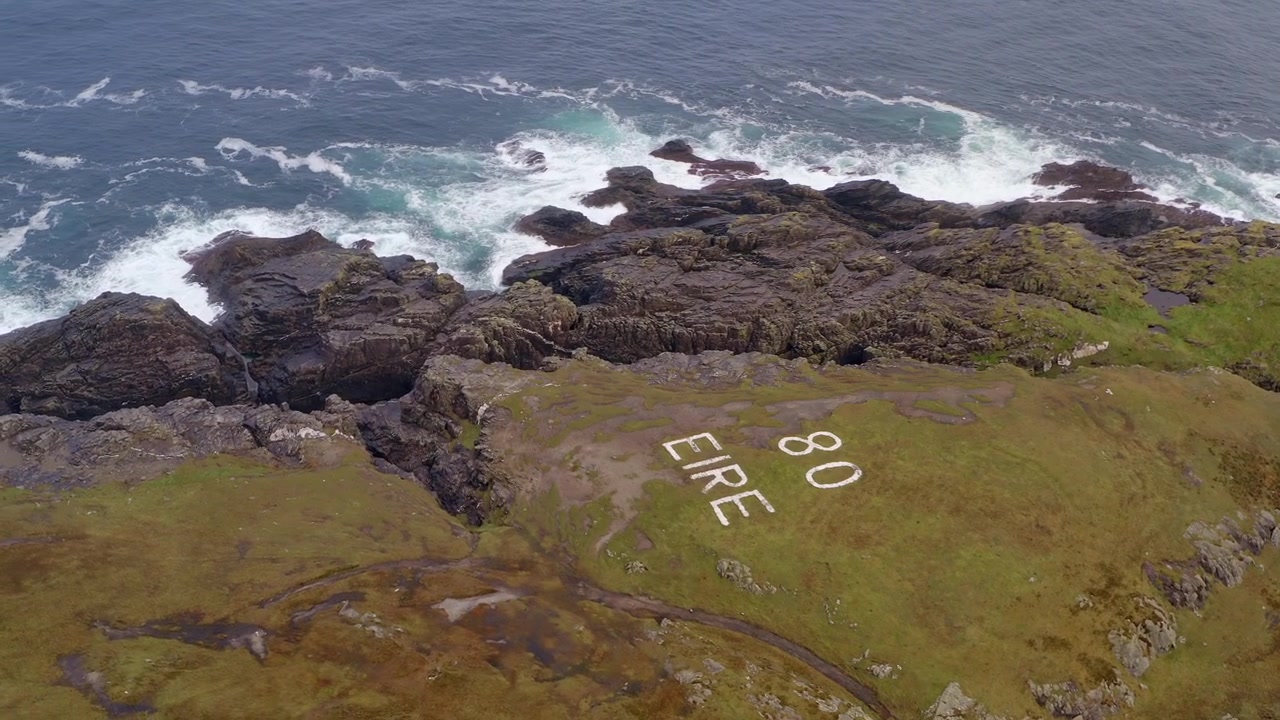 Pemandangan udara markah tanah Malin Head dengan tanda Eire-nya di dekat pantai yang terjal