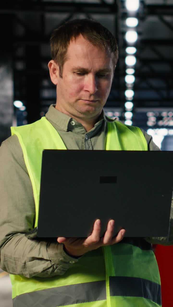 Vertical Video Portrait of technician handling metal tools on laptop from the factory floor
