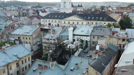 Aerial-drone-of-a-rooftop-bubble-restaurant-in-Lviv-Ukraine-surrounded-by-old-European-buildings-during-sunset