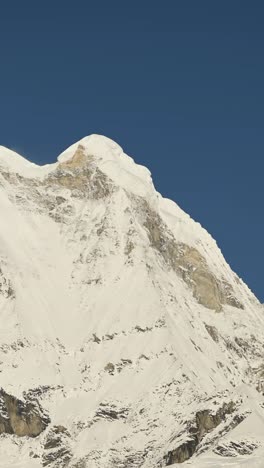 vertical snowy mountain top close up and clear blue sky, vertical nature landscape video for social media instagram reels and tiktok of snowcapped himalayas mountains
