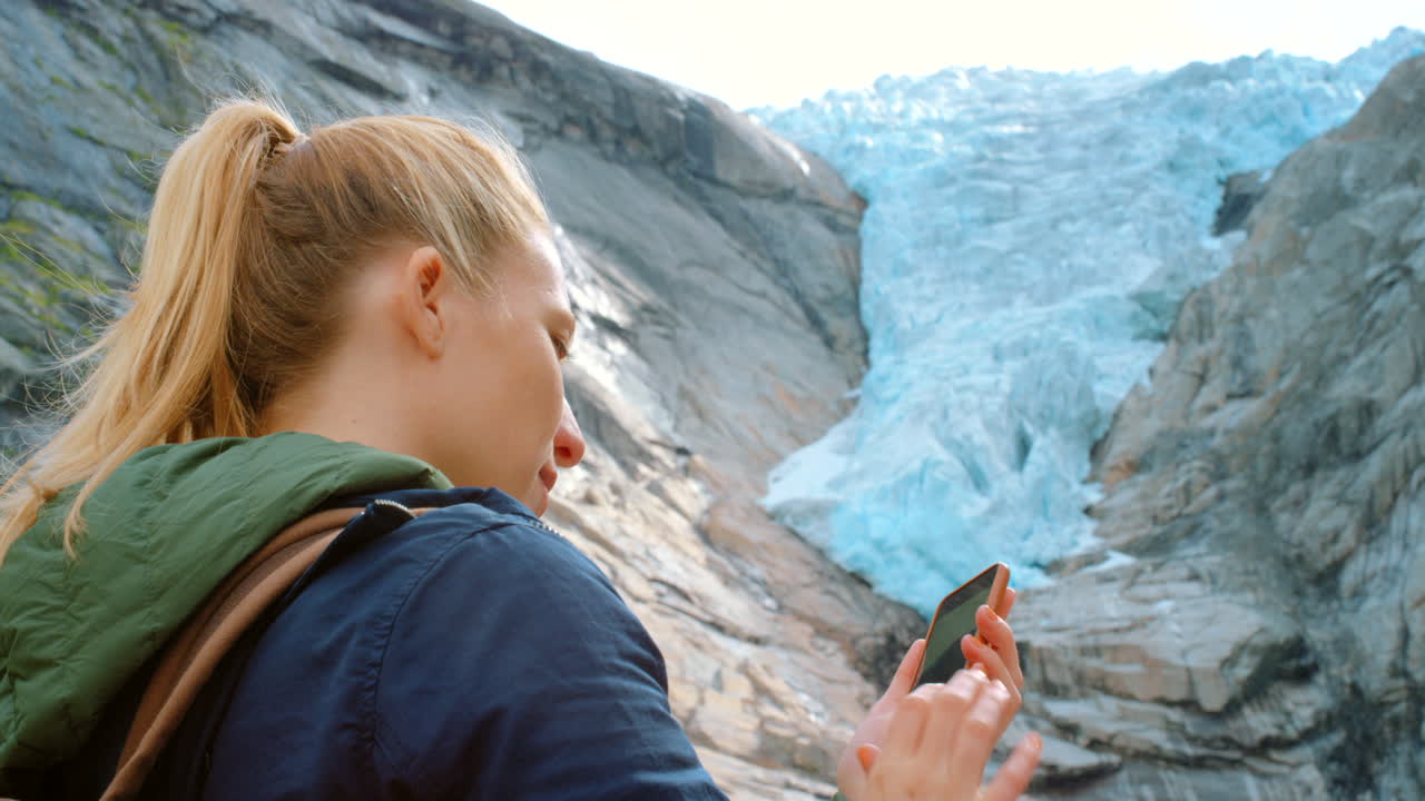 женщина фотографирует ледник.