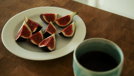 Schöne-Reife-Geschnittene-Feigen-Auf-Einem-Weißen-Teller-Mit-Kaffee-Am-Morgen-Vergrößern