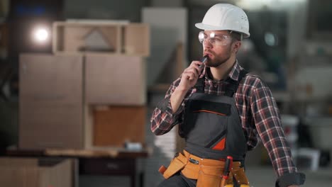 attractive-young-man-in-work-uniform-smokes-an-electronic-cigarette