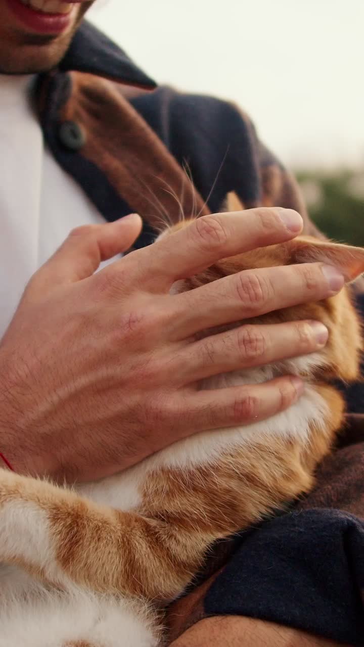 Man cuddling a ginger cat