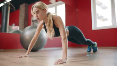 Athlete-woman-training-push-up-exercise-in-gym-club.