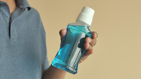 person holding a bottle of mouthwash