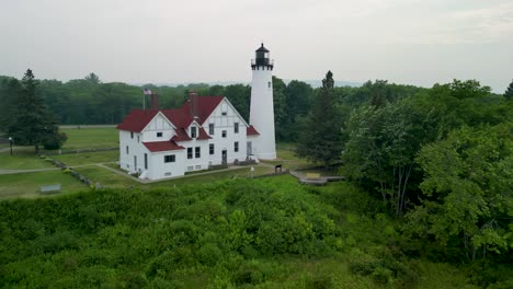 Aerial-view-ascending-approach-of-Point-Iriquois-Lighthouse,-Lake-Superior,-Michigan