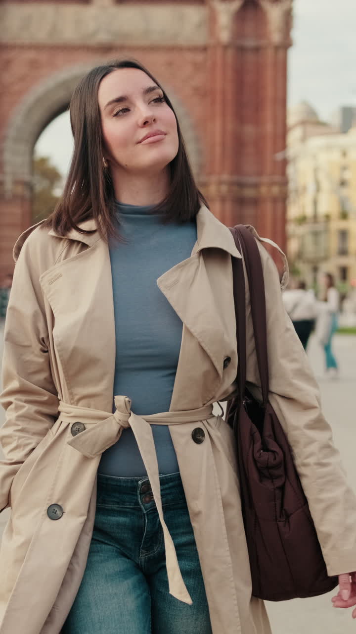 Young Woman Standing and Looking Around in Front of a Historic City Arch