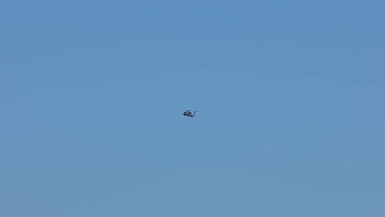 푸른 하늘과 햇빛으로 영공을 비행하는 헬리콥터의 넓은 샷