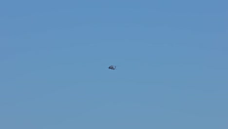 Wide-shot-of-helicopter-flying-in-airspace-with-blue-sky-and-sunlight