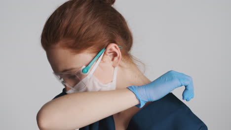 redheaded doctor in front of camera on gray background.