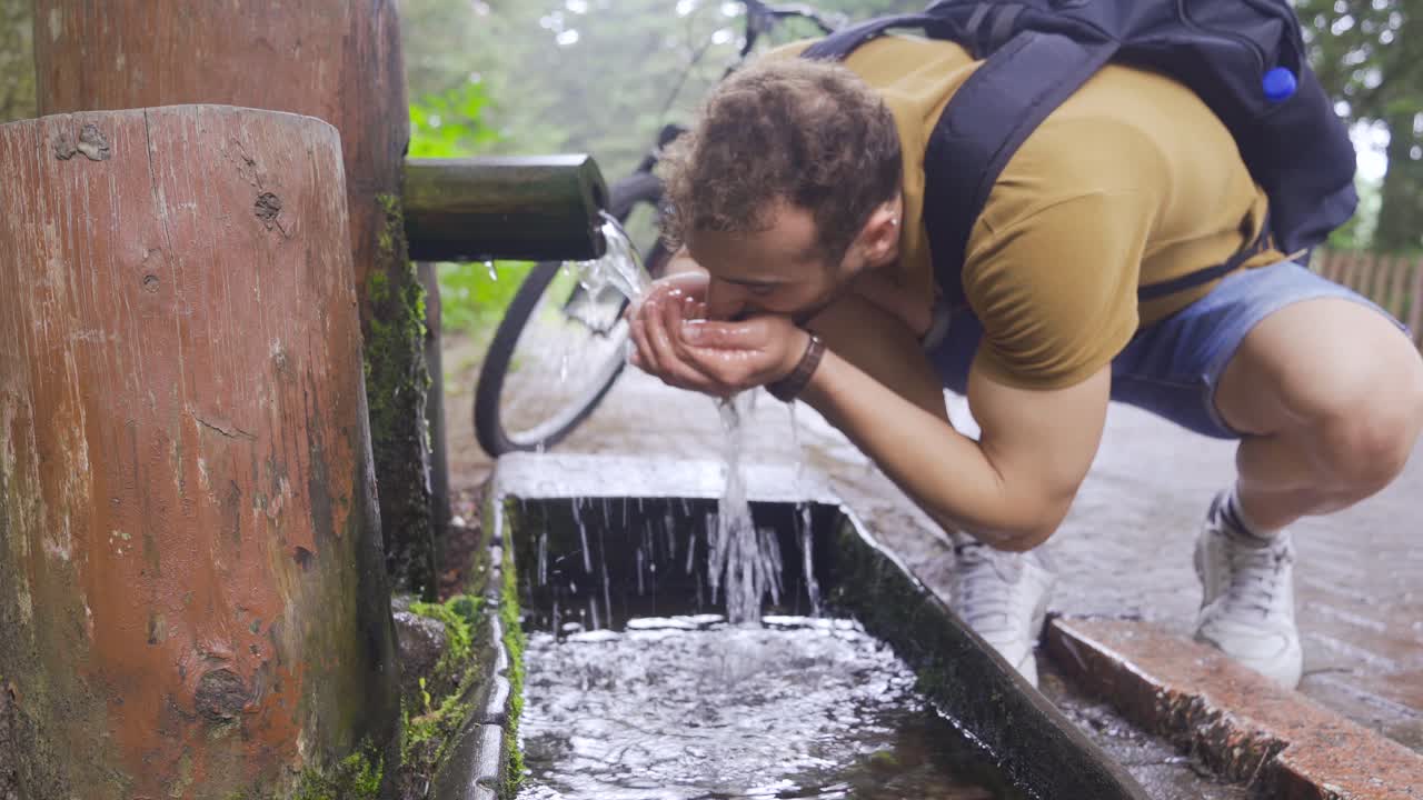 bebiendo agua clara de la fuente en el bosque.