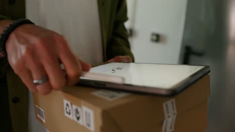 persona que firma para una entrega de paquetes usando una tableta