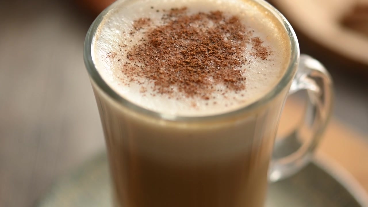 Latte d'acero con cannella in tazza di vetro