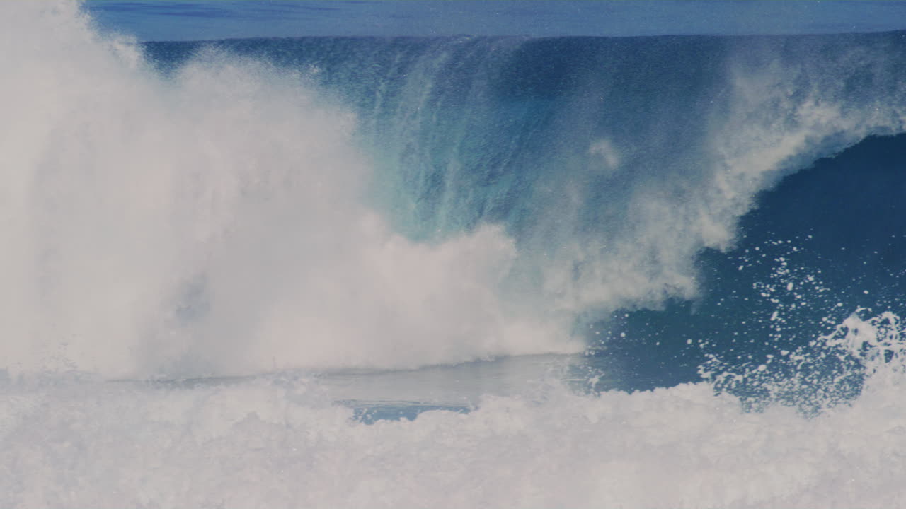 Surfer drops in on heavy wave at Cloudbreak Fiji and kicks board out from under feet