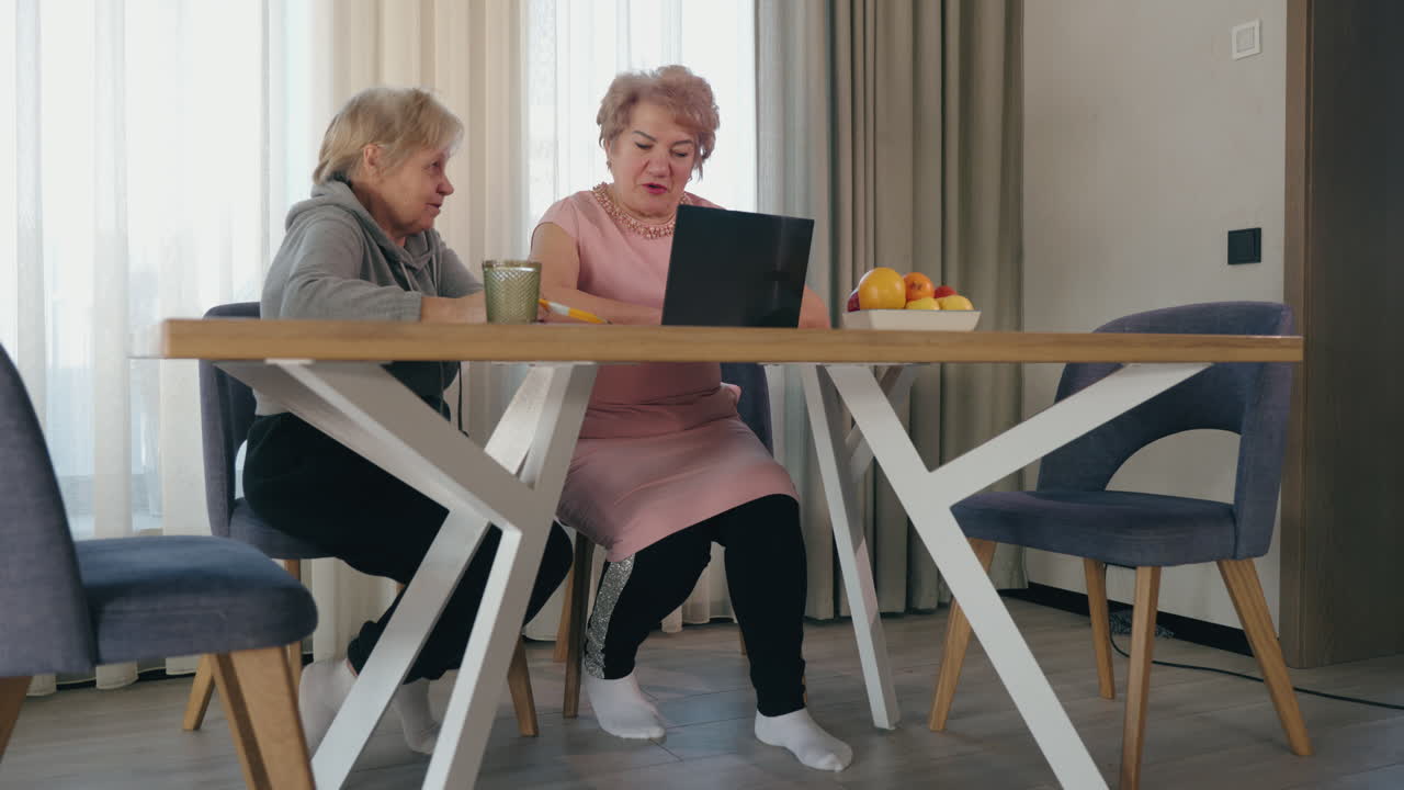 태블릿을 사용하는 두 명의 고령 여성