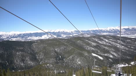 viewing snow capped mountains on a cloudless day from a ski lift, handheld