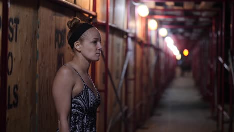 Redhead-Woman-alone-in-dark-alleyway-with-her-Smartphone