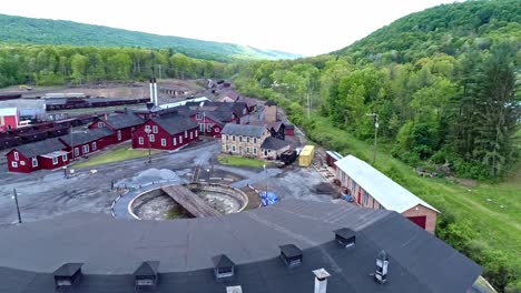 an aerial view of an abandoned narrow gauge coal rail road round house and turntable and support building starting to be restored