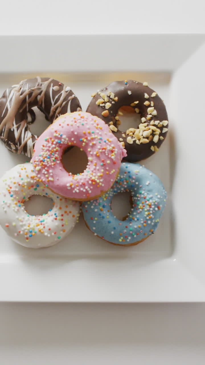 video de rosquillas con glaseado en una placa blanca sobre un fondo blanco
