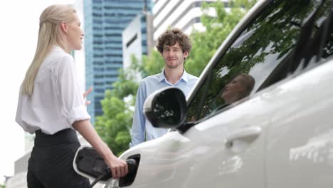 Empresario-Y-Empresaria-Progresistas-Utilizan-La-Estación-De-Carga-Para-El-Coche-Ev.