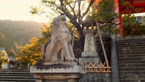 Slide-shot-of-a-lion-statue-with-the-sunrise-in-the-background-in-Kyoto,-Japan-4K-slow-motion