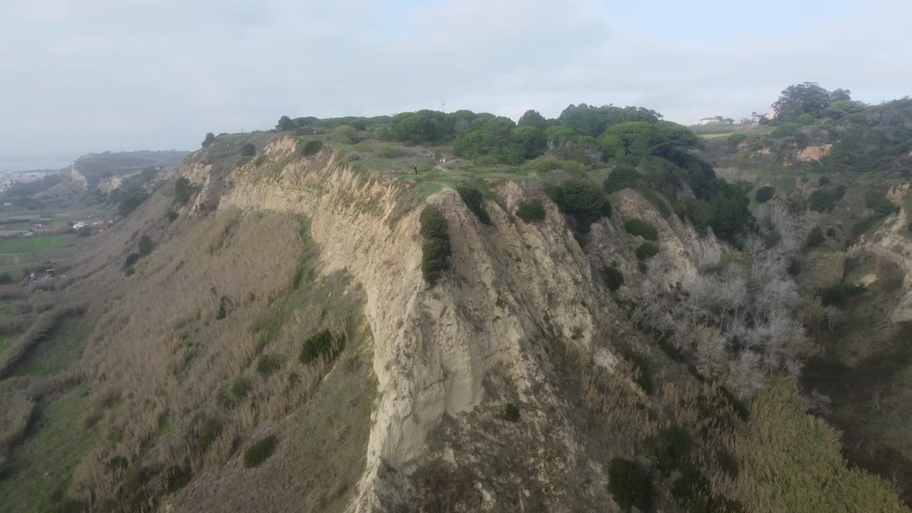 A long drone shot flying backwards revealing a beautiful cliffside in Costa Da Caparica, Portugal.