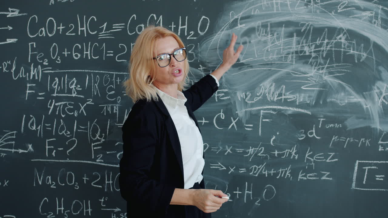 Teacher Explaining Chemistry Equations on Chalkboard