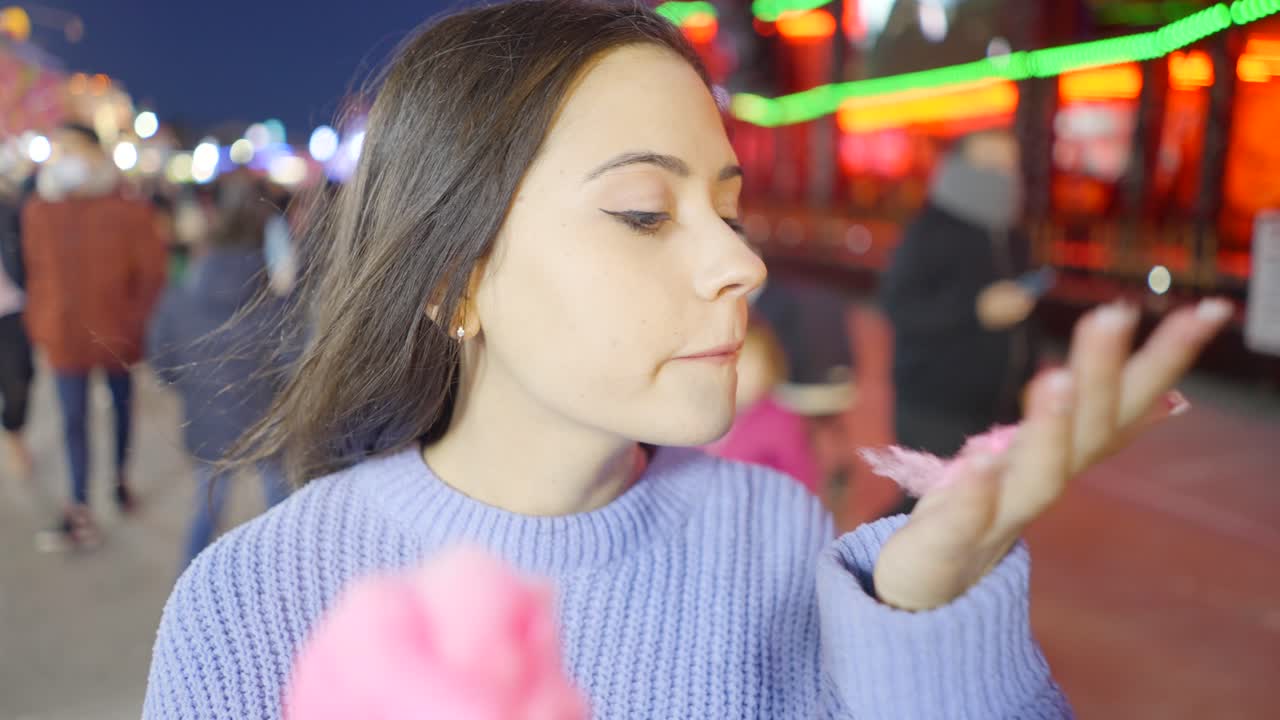 Woman enjoying cotton candy at a night market
