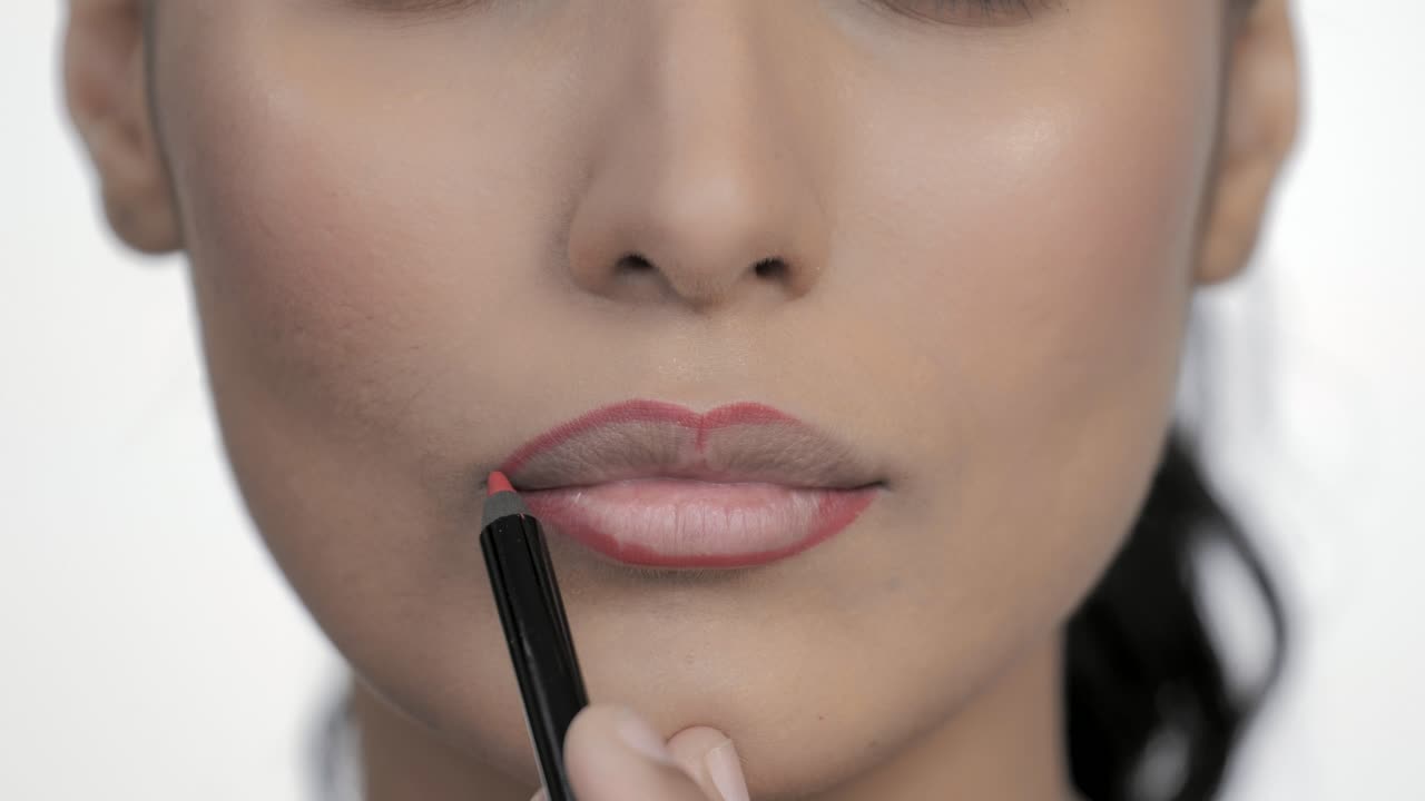 maquillador aplicando contorno de labios con crayón cosmético