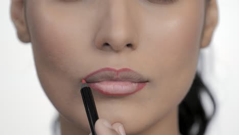 makeup artist applying lips contour with cosmetic crayon