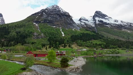 the jostedal glacier national park center - building with visitor information and museum and edge of the glacier seen in towering mountains in background - norway