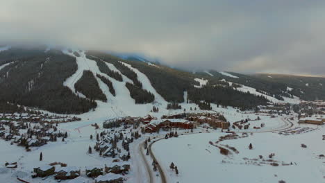 Foggy-cloud-layer-winter-snowy-early-morning-sunrise-aerial-drone-Copper-Mountain-Colorado-ski-resort-village-Eagle-Flyer-Super-Bee-lift-Ikon-Epic-Pass-cars-on-road-snowboarding-tubing-ski-left-circle