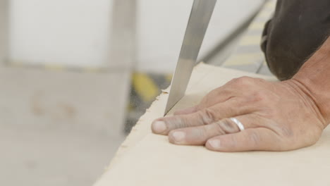 man cutting up a piece of wood with a saw