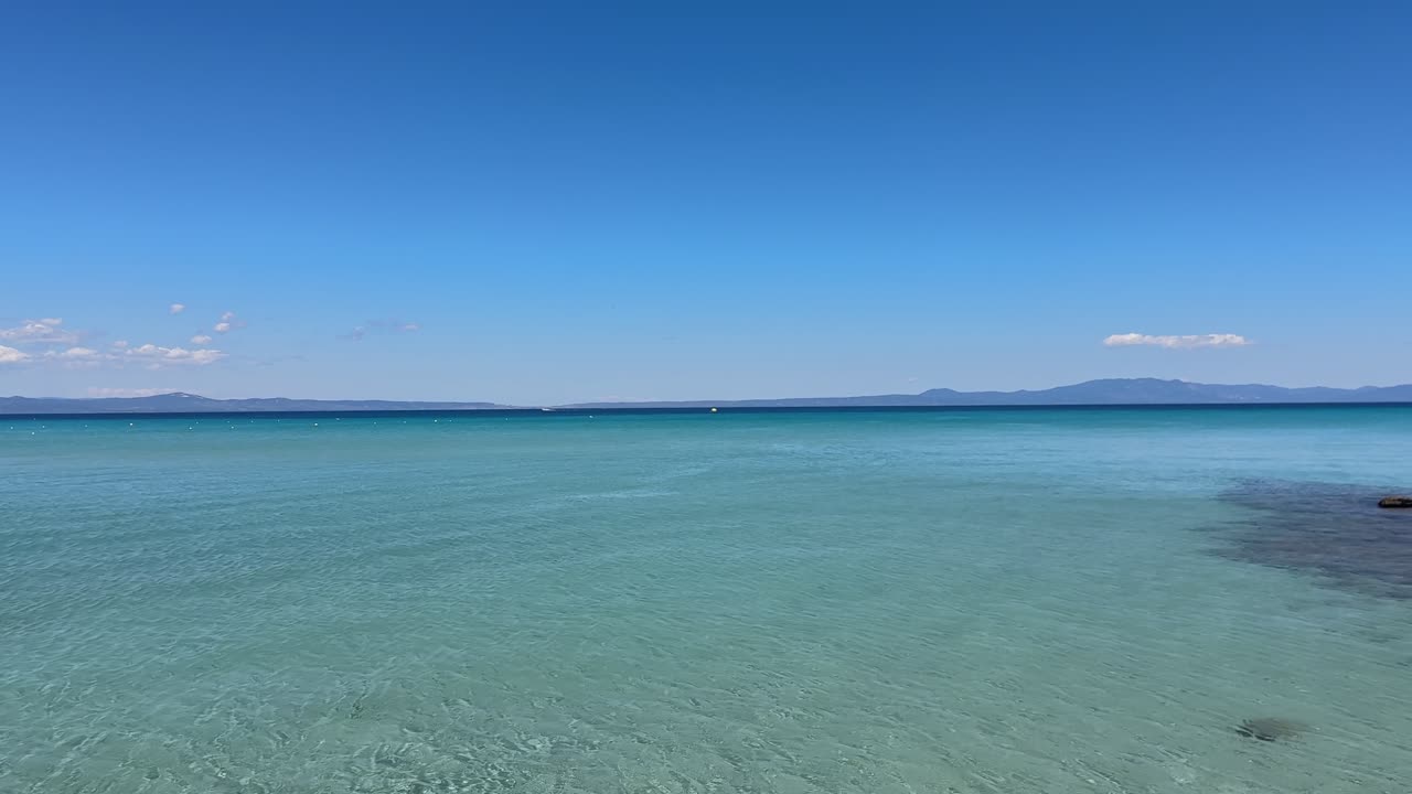 Stunning beach scene in Halkidiki, Greece, with elegant sunbeds facing the crystal-clear turquoise sea. A perfect summer escape in the heart of the Aegean.