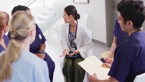 video of asian female doctor talking with diverse medical colleagues in hospital meeting