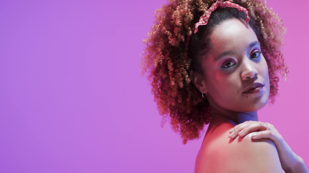 mujer biracial con cabello oscuro en luz azul y rosa con espacio de copia, cámara lenta