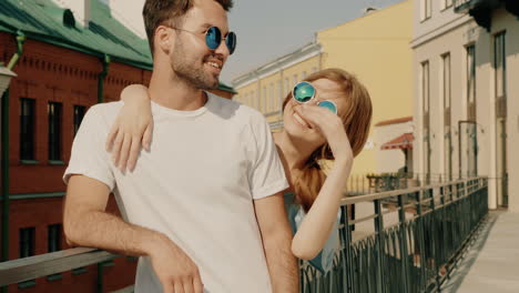una pareja con gafas de sol en una ciudad.