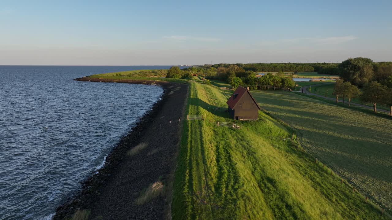 water works infrastructure in The Netherlands. dike, flood barrier, green landscape, waterline. Aerial view.